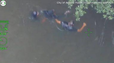 Police officers swim after fleeing suspect